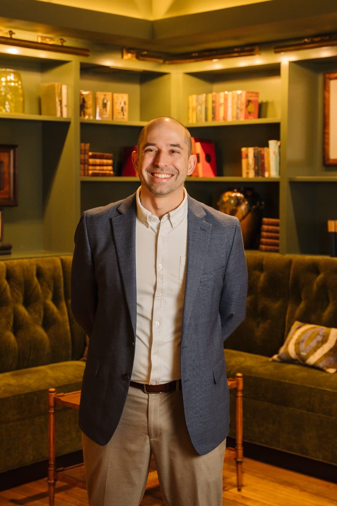 Dave Knox standing in a library with green bookshelves